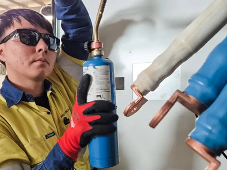 Kris Electrical Services electrician heat shrinking copper lugs on large cables in a main switchboard
